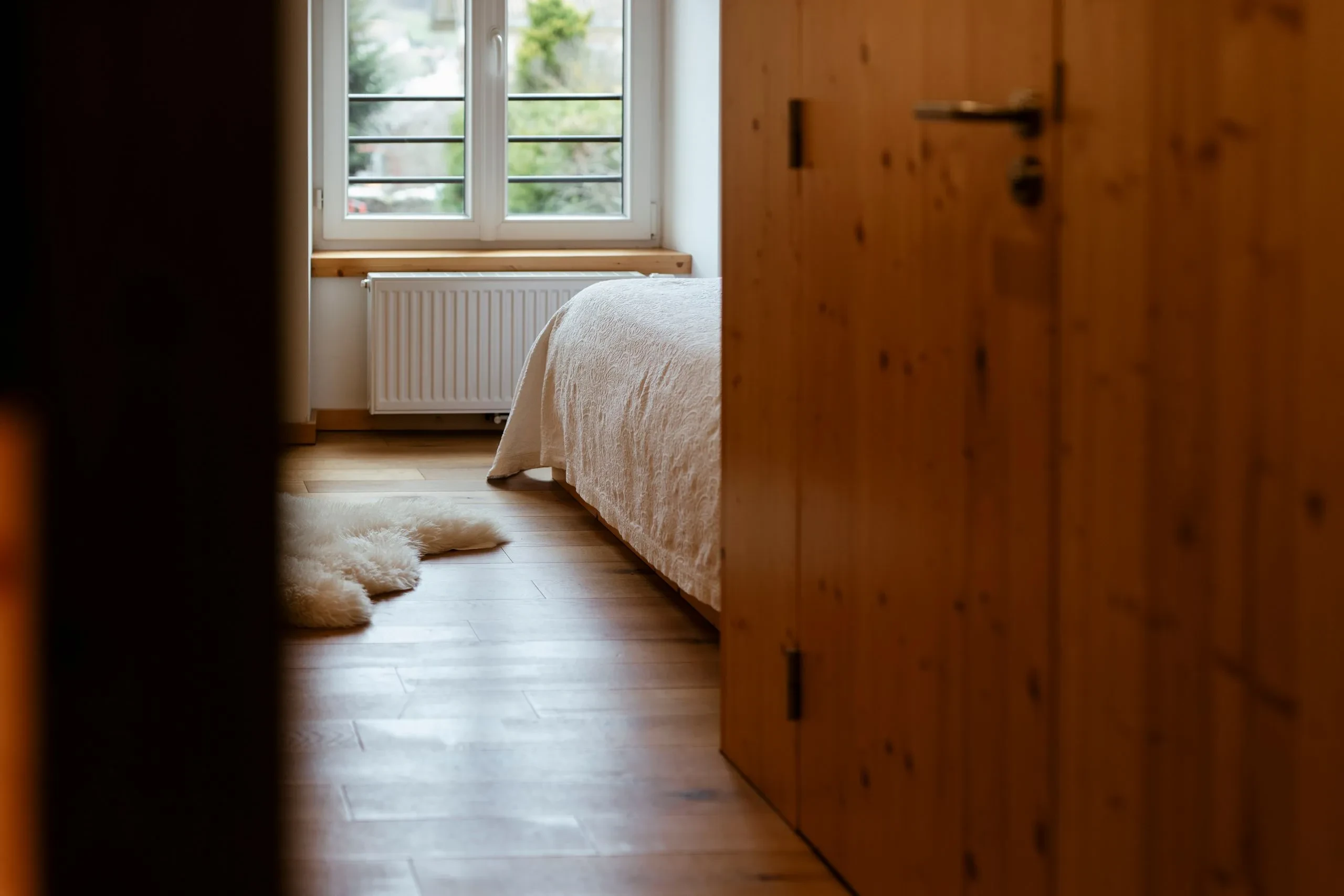 Cozy bedroom with fluffy rug and wooden floor