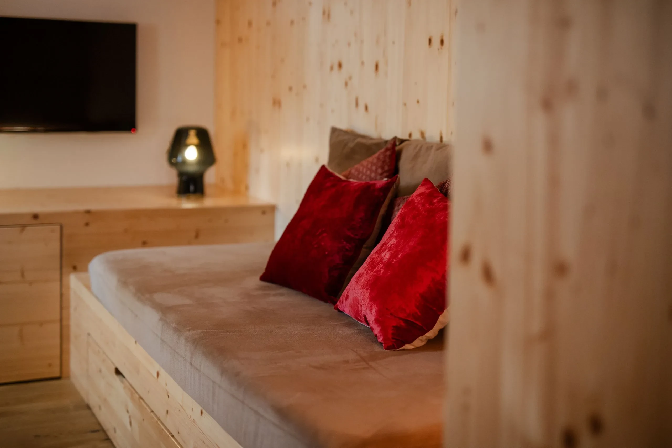 Cozy wooden room with red pillows