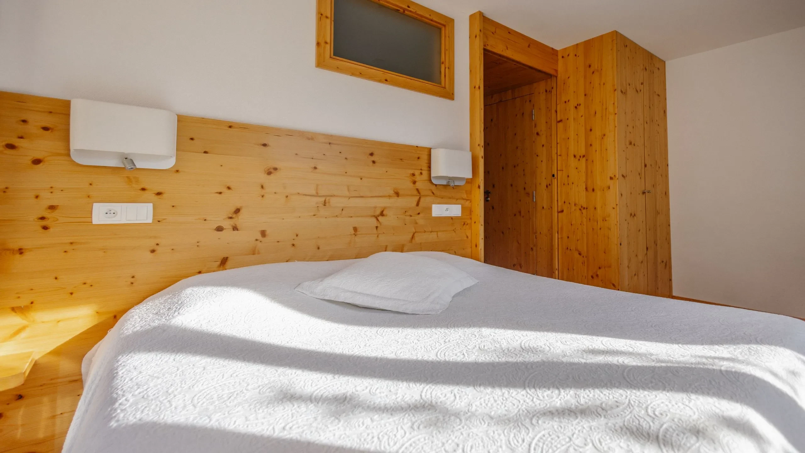 Cozy wooden bedroom with white bedding